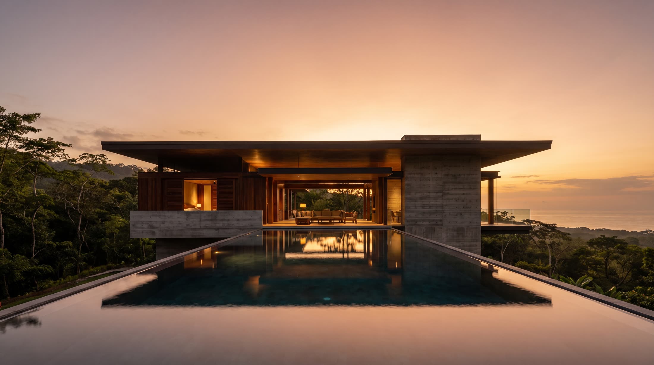 A villa and its pool above the jungle at dusk